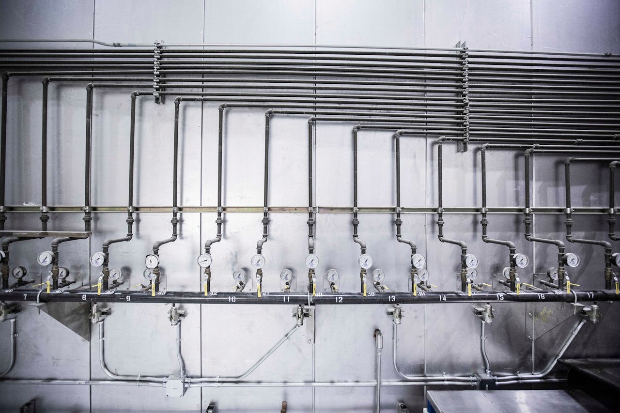 hero-homepage Detailed view of an industrial plumbing system featuring multiple pressure gauges and steel pipes.